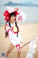 A woman in a red and white outfit holding a stick.