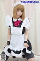 A woman in a maid outfit is posing for a picture.