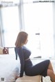 A woman sitting on a bed in a room.