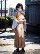 A woman in a kimono is standing on the street.