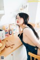 A woman sitting at a kitchen counter with a toaster.