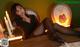 A woman sitting on top of a bed next to a clock.