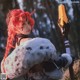 A woman with red hair holding a sword and shield.