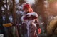 A woman in a costume holding a sword in the woods.