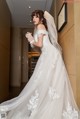 A woman in a wedding dress standing in a hallway.