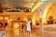 A woman in a white dress standing in a lobby.