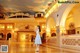 A woman in a white dress standing in a lobby.