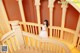 A woman in a white dress standing on a staircase.