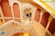 A woman in a white dress standing on a spiral staircase.