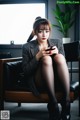 A woman sitting on a chair holding a cell phone.