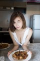 A woman sitting at a table with a plate of food.