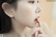 A woman with her hand on her chin looking away from the camera.