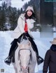 A woman riding on the back of a white horse.