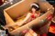 A woman in a santa hat is sitting in a cardboard box.