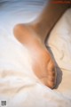 A close up of a person's foot on a bed.