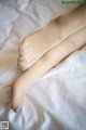 A pair of bare feet on a white sheet.