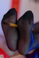 A pair of black and blue stockings with a pencil in their toes.