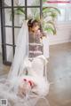 A woman in a wedding dress sitting on the floor.