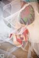 A close up of a woman's wedding dress and red shoes.