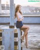 A woman sitting on top of a metal pole.