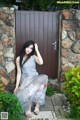 A woman sitting in front of a wooden door.