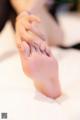 A woman's feet with a manicure on a bed.