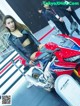 A woman sitting on top of a red and white motorcycle.