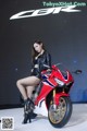 A woman sitting on top of a red and white motorcycle.