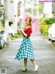 A woman walking down a street holding an umbrella.