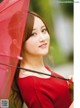 A woman in a red dress holding a red umbrella.