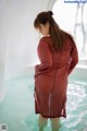 A woman in a red dress standing in the water.